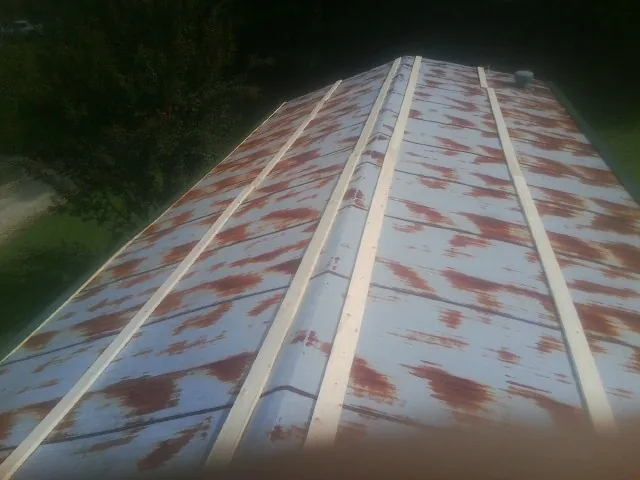 Rusted metal roof panels with new wood purlins before replacement — Storm Damage Roof Repair in Gay by Roofing Brothers